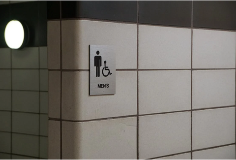 "A sign indicating a designated area or facility, such as a restroom or a specific section in a building.